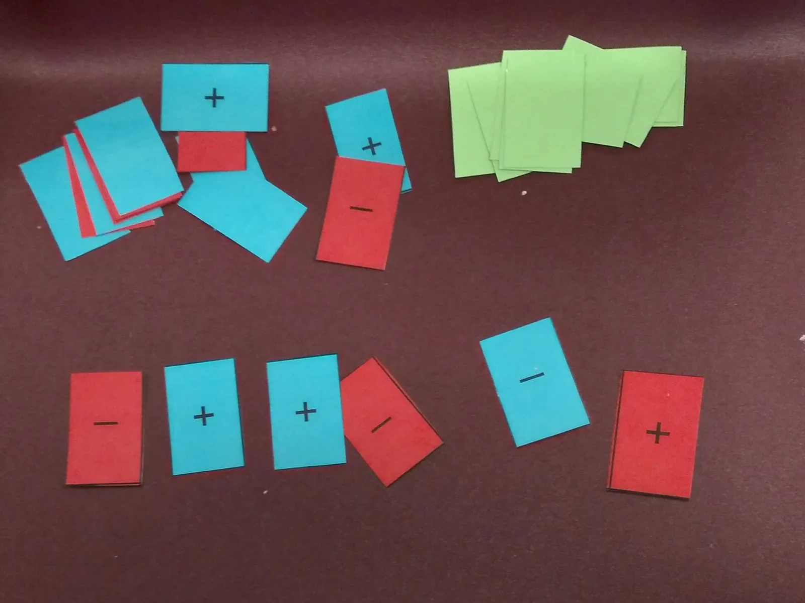 Game cards in three different colors with the symbols + and -