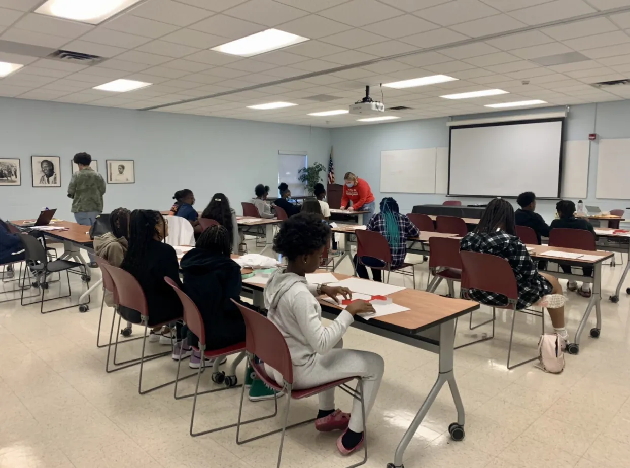 Image from Hidden Figures Workshop on dragon fractals. Features rows of students working at desks.